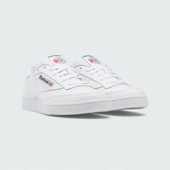 Angled view of two Reebok Classic Club C 85 Unisex white trainers, side by side, showcasing their timeless aesthetic and classic court design.