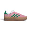 Side Profile Image: Studio lateral shot of the adidas Gazelle Bold in True Pink and Green, highlighting the soft pink suede upper, green serrated three stripes, gold foil Gazelle branding, and the triple-stacked gum rubber platform midsole.