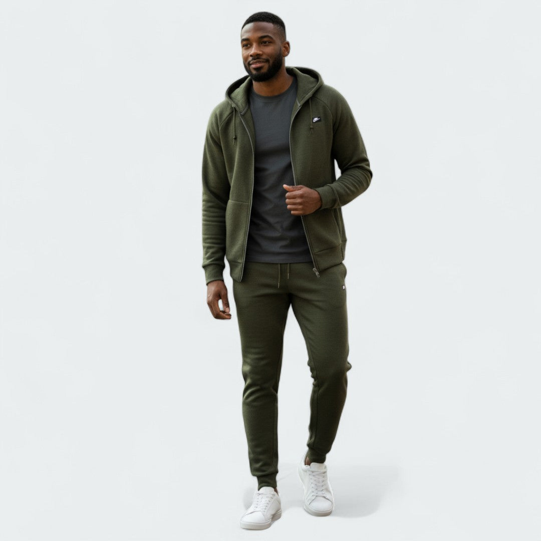 Nike NSW Optic Tracksuit in olive green, front view worn by a model showing the full-zip hoodie and matching tapered pants.