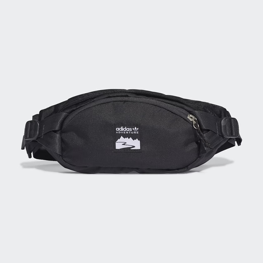 Adidas Adventure Waist Bag in black, front view showing main zip pocket, front zip pocket, and woven Adidas brand patch.