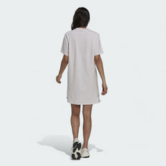 Adidas Tennis Luxe Tee Dress Women's in ambient blush pink, back view on a model, highlighting the loose drape and comfortable silhouette.