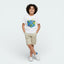Child wearing a white t-shirt with a colorful graphic design on a plain background