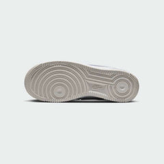View of the outsole of the Nike Air Force 1 LV8 Juniors' white trainers, showing the durable rubber sole with pivot circles for traction.