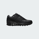 Nike Air Max 90 Juniors' trainers in all black with a white midsole accent, side profile showing visible Max Air unit and classic layered design.