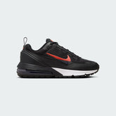 Nike Air Max Pulse Juniors' trainers in black with university red accents, side profile showing visible point-loaded Max Air unit and layered textile upper.