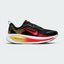 Highlights the high-velocity sweep of the contrasting crimson Nike Swoosh, showing the professional texture of the black engineered mesh upper, the topaz gold accenting, and the massive, high-walled stacked ZoomX and ReactX foam midsole base.