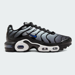 Nike Air Max Plus TN Juniors' trainers in white with racer blue and black accents, side profile showing visible Tuned Air units and distinctive wavy overlays.