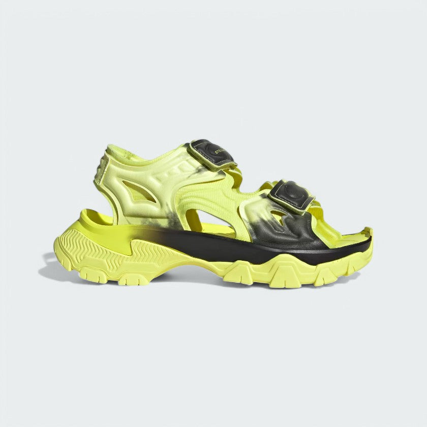 Adidas by Stella McCartney Hika Sandal in frozen yellow, side profile showing adjustable hook-and-loop straps, chunky sole, and collaborative branding.