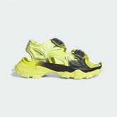 Adidas by Stella McCartney Hika Sandal in frozen yellow, side profile showing adjustable hook-and-loop straps, chunky sole, and collaborative branding.