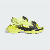 Adidas by Stella McCartney Hika Sandal in frozen yellow, side profile showing adjustable hook-and-loop straps, chunky sole, and collaborative branding.