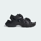 Adidas by Stella McCartney Hika Sandal in black, side profile showing adjustable hook-and-loop straps, chunky sole, and collaborative branding.