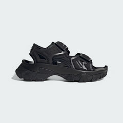 Adidas by Stella McCartney Hika Sandal in black, side profile showing adjustable hook-and-loop straps, chunky sole, and collaborative branding.