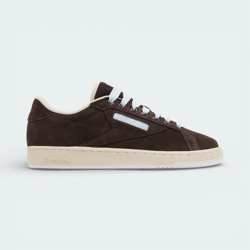 Side profile of the Reebok x SNEEZE Club C Grounds in Earth brown suede, showing the tonal side stripes and the contrasting Stucco white rubber outsole.