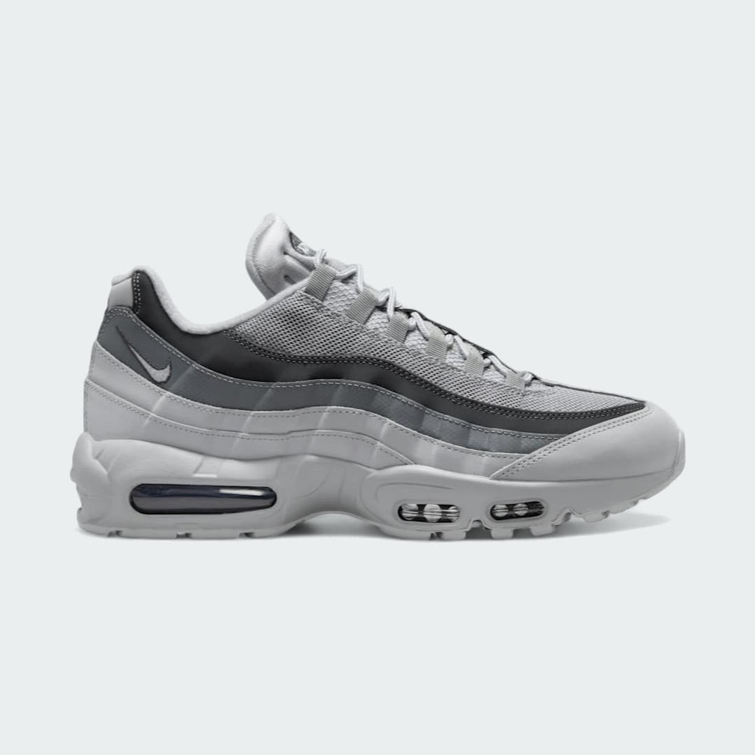 Nike Air Max 95 Men's running shoes in shades of grey, side profile showing visible Max Air units in the heel and forefoot, and a layered upper.