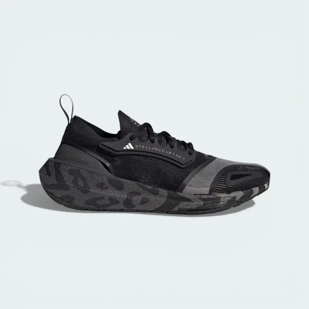 Side profile of the black and white Stella McCartney Ultraboost, showing the sleek PRIMEKNIT upper and the thick Light BOOST midsole.