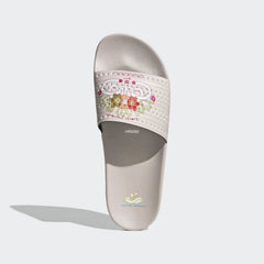 Top-down view of a pair of Adidas Adilette Slides Unisex in pink, highlighting the three white stripes on the strap and the footbed.