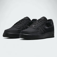 Angled view of two Nike Air Force 1 Low Canvas Men's black trainers, side by side, showcasing their timeless design and clean aesthetic.