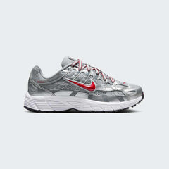 Nike P-6000 Juniors' trainers in metallic silver with gym red accents, side profile showing layered mesh and synthetic/leather overlays.
