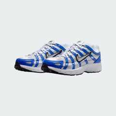 Angled view of two Nike P-6000 Juniors' trainers in blue and silver, side by side, showcasing their chunky, retro-inspired aesthetic.