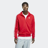 Adidas Adicolor Classics Firebird Track Jacket Men's in better scarlet red, front view showing full zip, stand-up collar, white 3-Stripes on sleeves, and embroidered Trefoil logo.