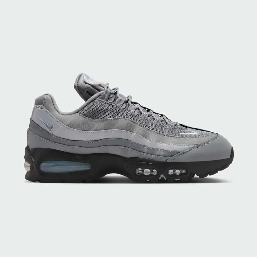 Nike Air Max 95 OG Men's running shoes in shades of grey with red and black accents, side profile showing visible Max Air units in the heel and forefoot, and a layered upper.