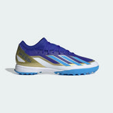 Adidas X Crazyfast League TF football boots in lucid blue with white and gold accents, side profile showing the textured synthetic upper and turf-specific rubber sole.