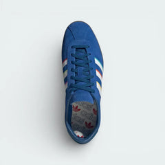 Top-down view of the limited-edition trainers, highlighting the premium suede texture, white laces, and the leather-lined collar.