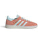 Side Profile Image: Studio lateral shot of the adidas Handball Spezial in Wonder Clay and Almost Blue, highlighting the dusty pink synthetic upper, pale blue serrated three stripes, gold foil SPEZIAL lettering, and a translucent rubber outsole.