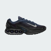 Nike Air Max DN Men's running shoes in dark navy with white accents, side profile showing visible Dynamic Air unit in the heel, textured upper, and sleek silhouette.