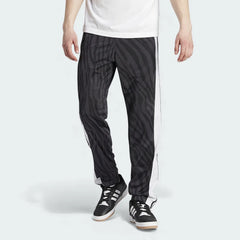 Adidas Adibreak Button Track Pants in black with a subtle animal print, front view showing the elastic drawcord waist and the full line of snap buttons down the side.