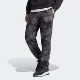 A pair of Adidas men's camouflage sweat pants with elastic waistband and zip pockets, in a gray and black color scheme.