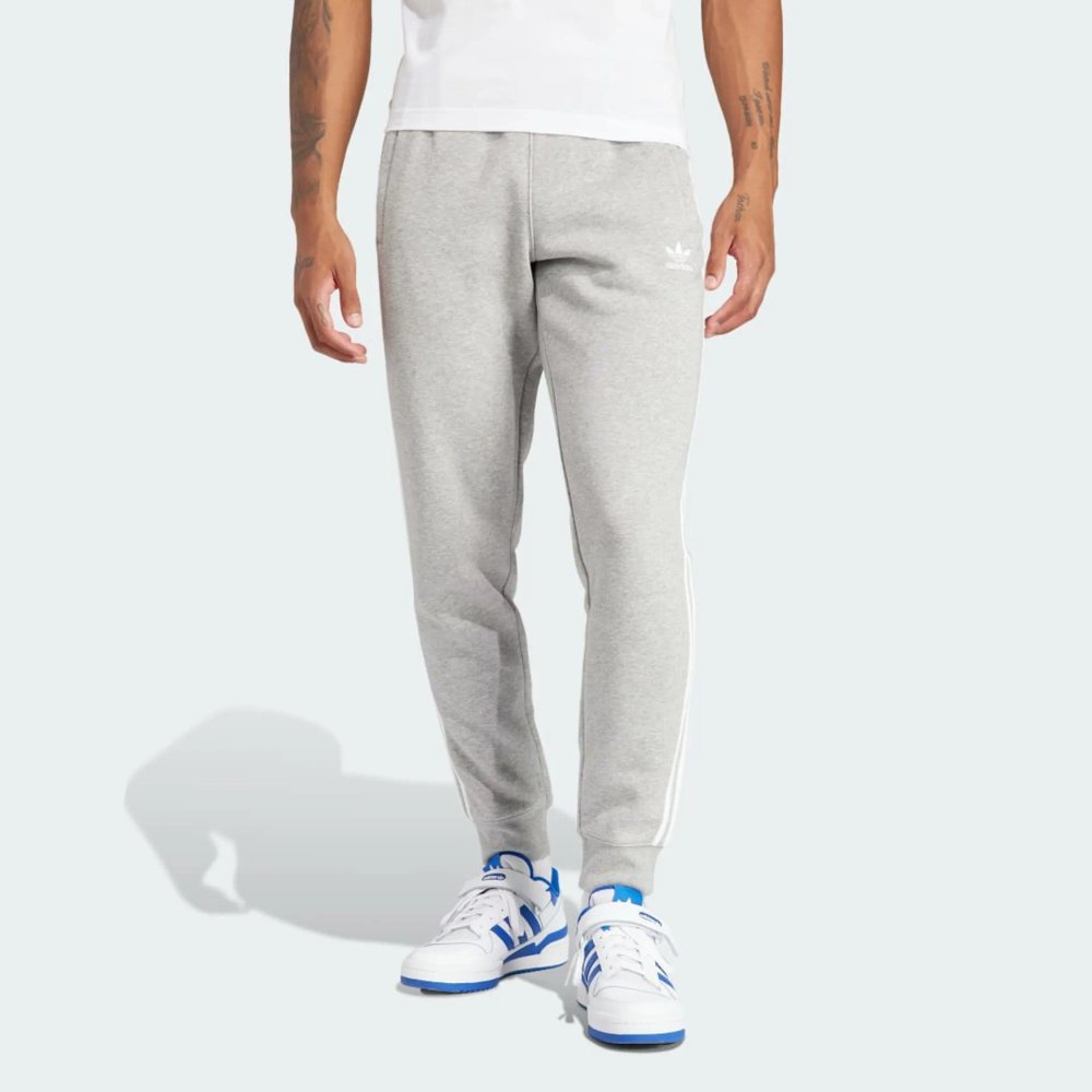Front profile of the Adicolor 3-Stripes joggers, showing the slim-fit silhouette and the iconic contrast stripes running down