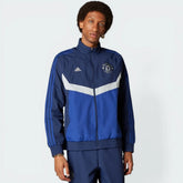 The Indigo Blue track top, highlighting the bold red and white color-blocking on the sleeves and the classic ribbed cuffs.