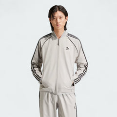 Front view of an Adidas Superstar Men's Bonded Track Top in Medium Grey (IW7318) on a model, showcasing its full design.