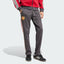 Side profile of the Utility Black Man Utd track pants, highlighting the slim, tapered leg and the classic 3-Stripes detailing.