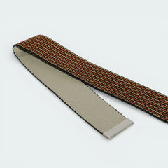 Detailed zoom on the strap’s edge, showing the contrast between the smooth black finish and the textured orange grain.