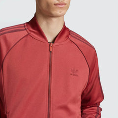 Close-up of the upper chest, focusing on the high-quality embroidery of the Trefoil logo and the sturdy metallic zipper pull.