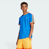 Model profile of the blue Adidas t-shirt, highlighting the slim fit and the textured ribbed cuffs on the sleeves.