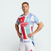 Front profile of the Arsenal 24/25 pre-match jersey, showing the slim-fit cut and the vibrant scarlet and aqua graphic pattern.