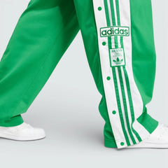 Close-up of the lower leg, focusing on the woven Adibreak patch and the high-quality metallic snap-button hardware