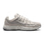 Highlights the early-2000s lateral silhouette featuring the Phantom textile mesh upper, layered Light Bone and Light Smoke Grey leather cage overlays, moulded Nike Swoosh with tonal borders, lifted Sail foam midsole, and dark rubber outsole tread.