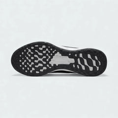 View of the outsole of the Nike Revolution 6 Next Nature Men's grey trainers, showing the durable rubber tread pattern with flex grooves for traction.