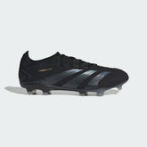 Adidas Predator Pro FG men's football boots in black with gold metallic accents, side profile showing the Strikeskin grip texture on the upper and the firm ground studs.