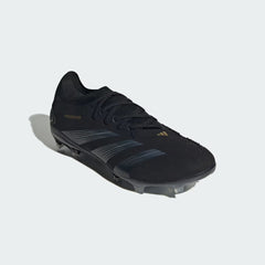 Angled view of Adidas Predator Pro FG men's football boots in black and gold, from the side, showcasing their elite design and aggressive profile.