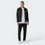 Focuses on the symmetry of the flat-laid track jacket, displaying the perfect alignment of the high stand-up funnel collar, the central zip track, and the balance of the embroidered Trefoil logo on the chest.