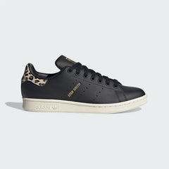 Adidas Stan Smith Women's trainers in black leather, side profile showing the perforated 3-Stripes and a leopard print heel tab.