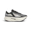 Studio side-profile shot of the adidas by Stella McCartney Prime x 2.0 STRUNG shoes in Cloud White, Grey One, and Core Black, highlighting the data-mapped STRUNG upper, stacked white midsole, Lightstrike Pro branding, and Continental rubber outsole.