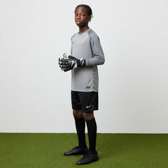 Young baller wearing a grey sports jersey and black shorts on a green and white background