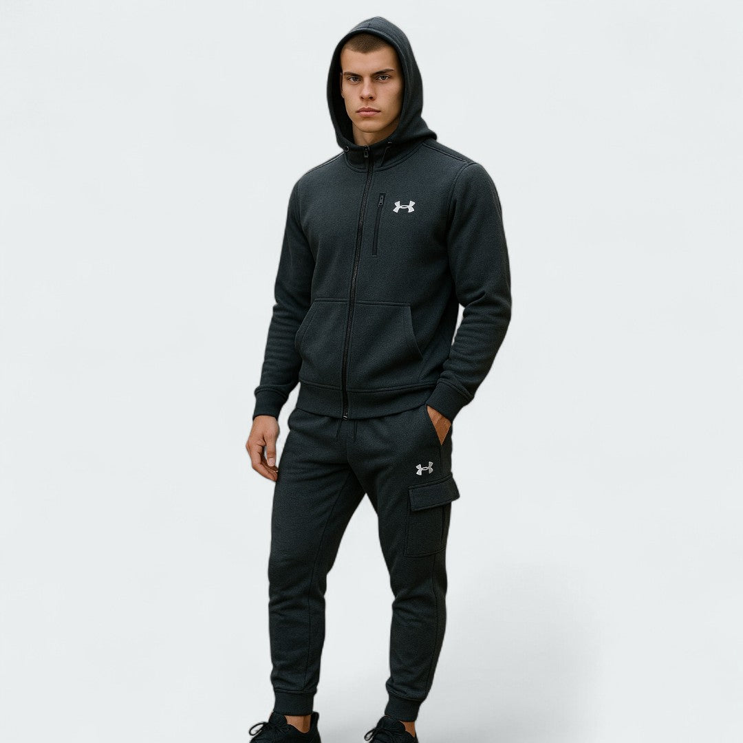 Under Armour Men's Fleece Cargo Tracksuit in black, front view on a model showing the hooded top with a kangaroo pocket and matching cargo joggers.