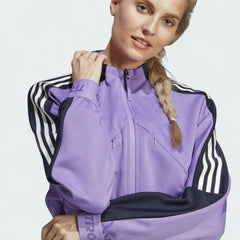 Close-up zoom on the fabric of the Adidas Tiro Track Top in purple, showing the double-knit texture and the embroidered Adidas logo.